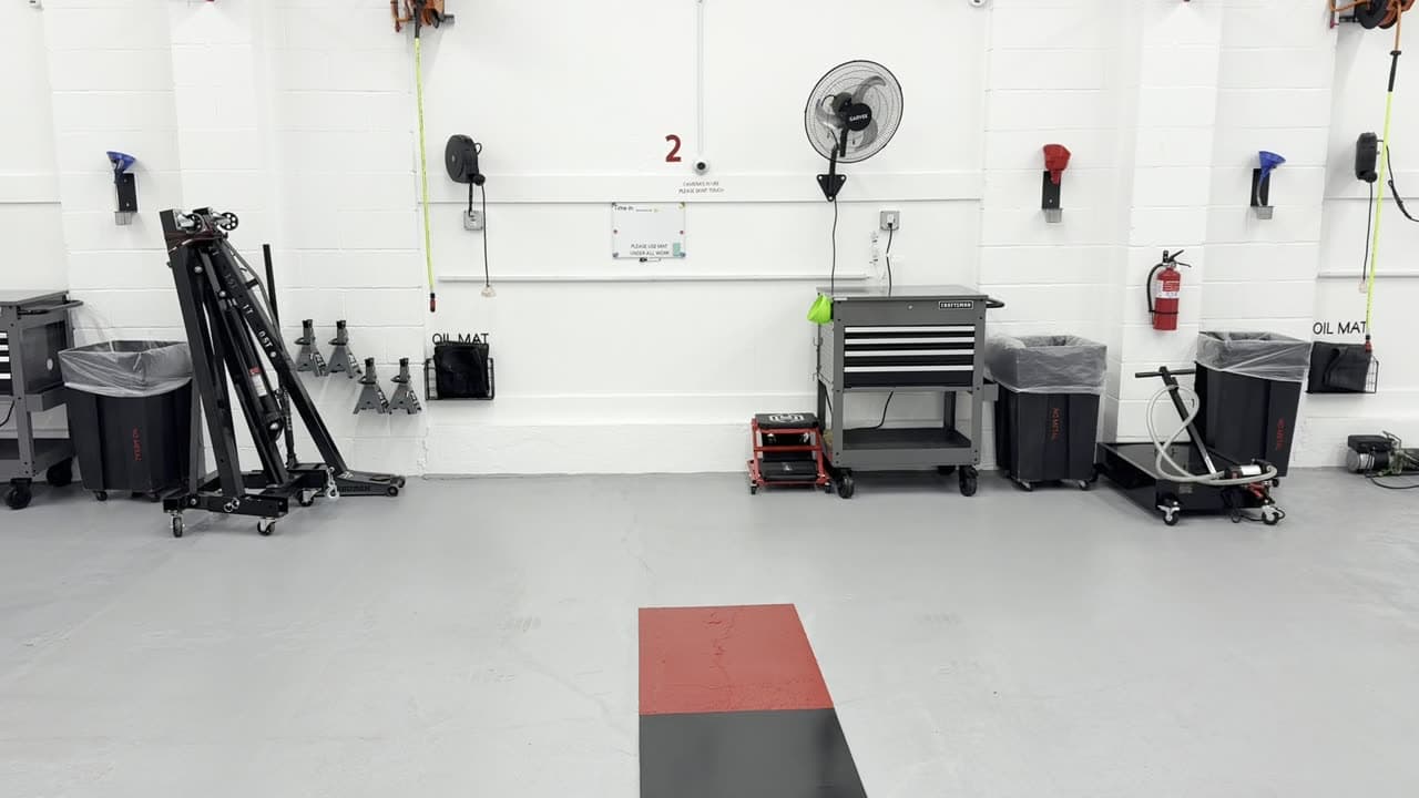 Inside Coopers Garage Toledo: three bays with a two-post lift and a QuickJack