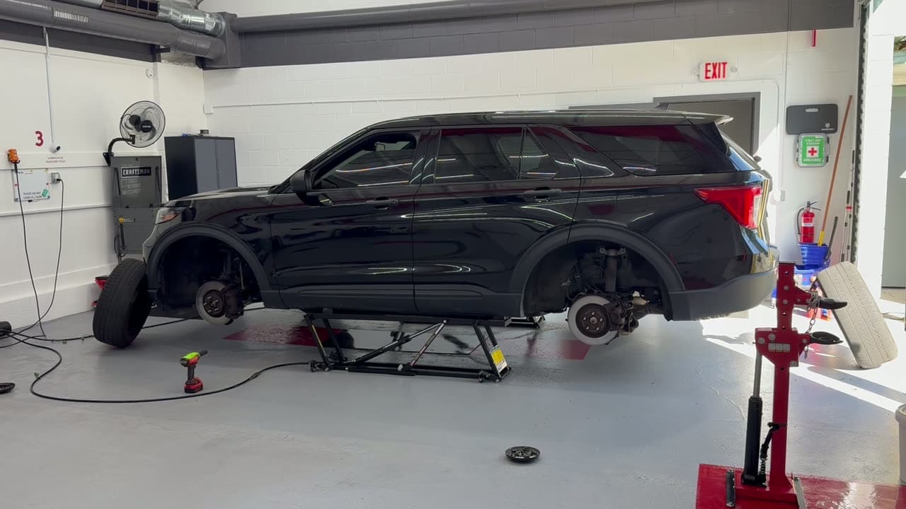 An SUV on a lift at Coopers Garage Toledo with the wheels off and the brake rotors showing