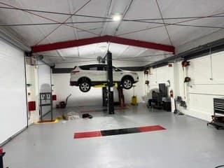 A customer's vehicle on a lift at Coopers Garage