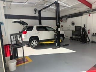 A customer's vehicle on a lift at Coopers Garage
