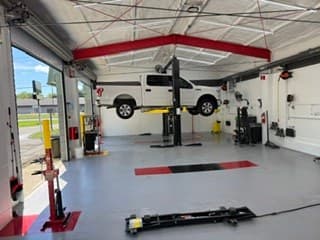 A customer's vehicle on a lift at Coopers Garage